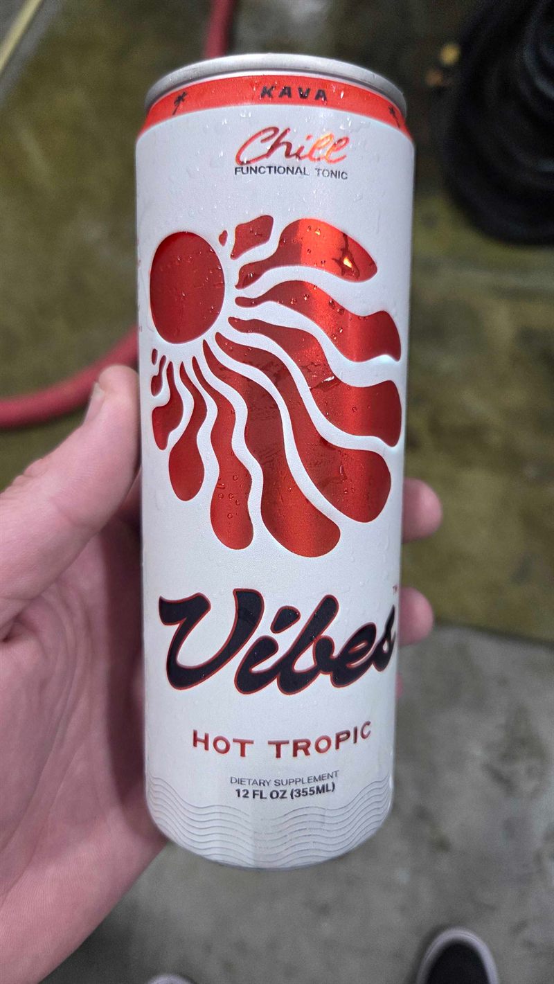 Hand holding a can of Hot Tropic